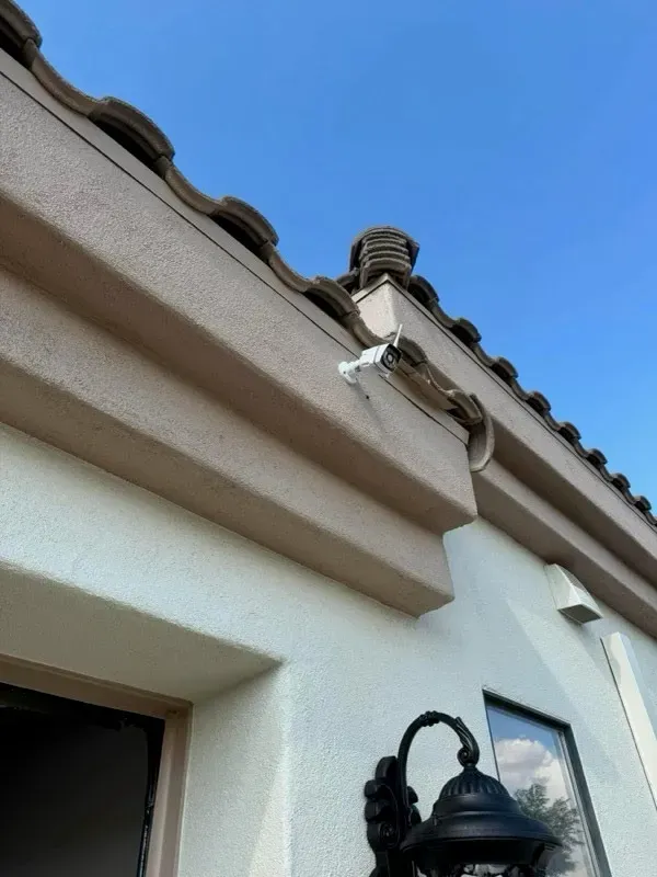 Security camera mounted under a tile roof eave - Orozco Electric low-voltage install