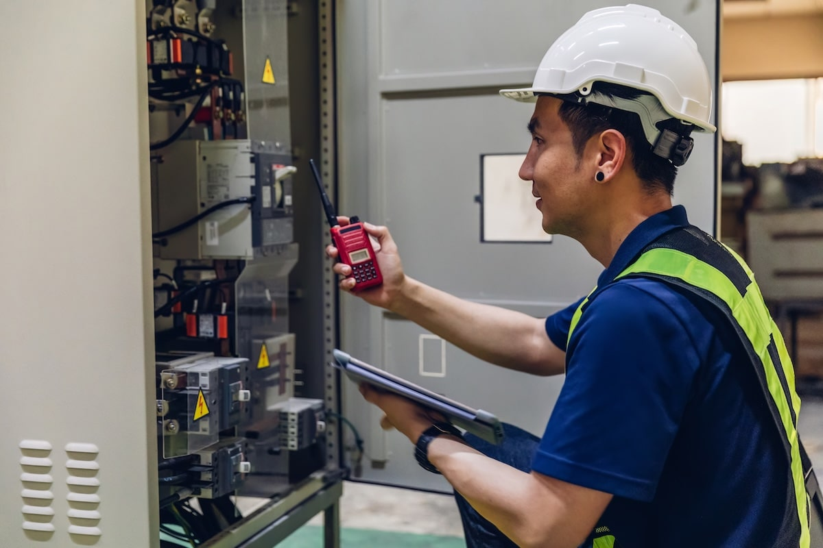 Electrician inspecting industrial panel